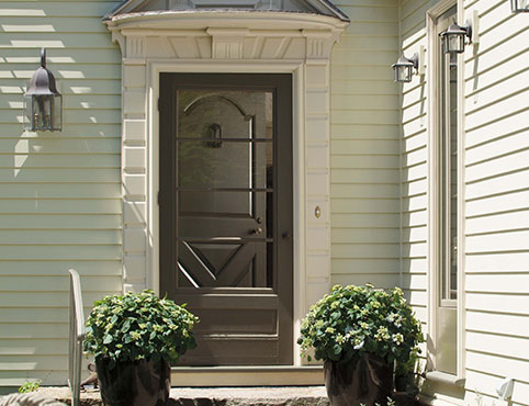 A beautiful home exterior with a dark brown front door, off-white-painted siding, and manicured landscaping. A beautiful home exterior with a dark brown front door, off-white-painted siding, and manicured landscaping.