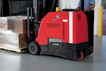 A warehouse employee operating a motorized pallet jack on a floor coated in Corotech® COMMAND®. A warehouse employee operating a motorized pallet jack on a floor coated in Corotech® COMMAND®.